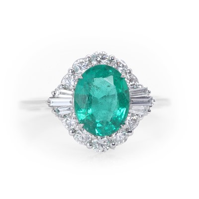 Lot 89 - An 18ct white gold emerald and diamond cluster ring