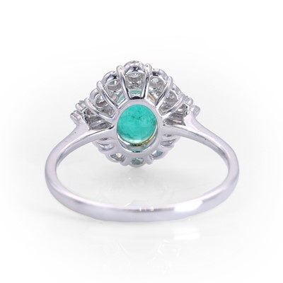 Lot 89 - An 18ct white gold emerald and diamond cluster ring