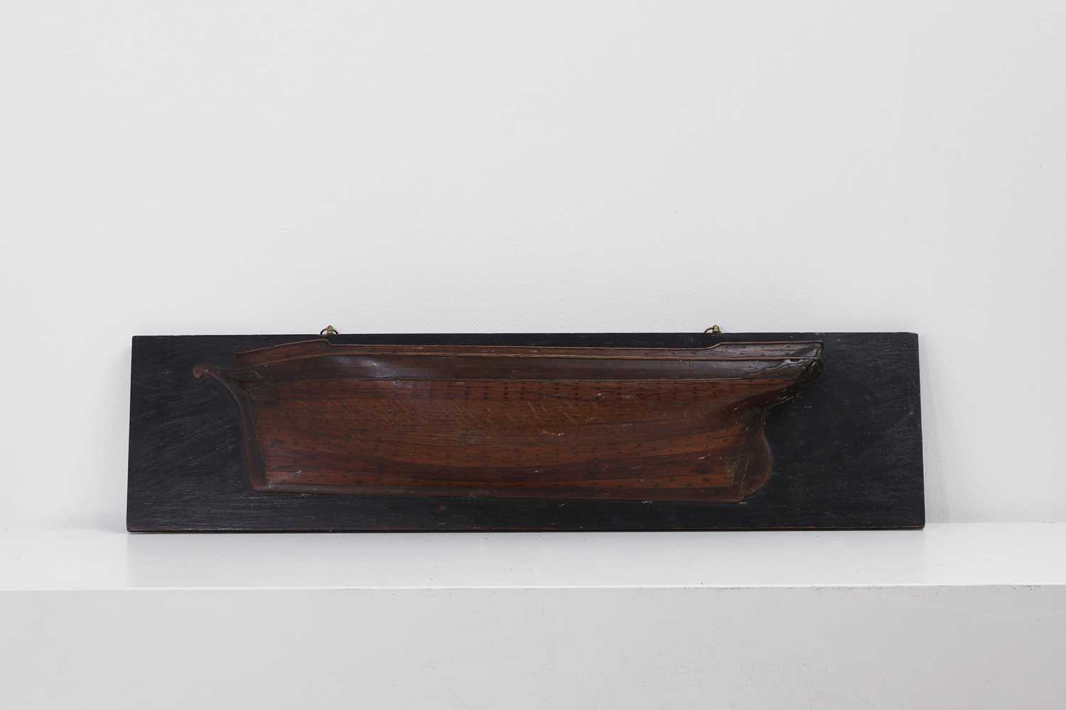 Lot 381 - A carved half-hull model of a ship