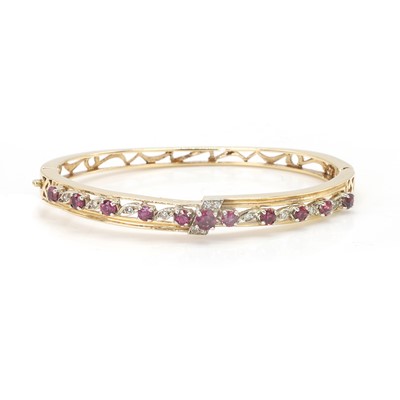 Lot 125 - A 14ct gold, ruby and diamond hinged bangle