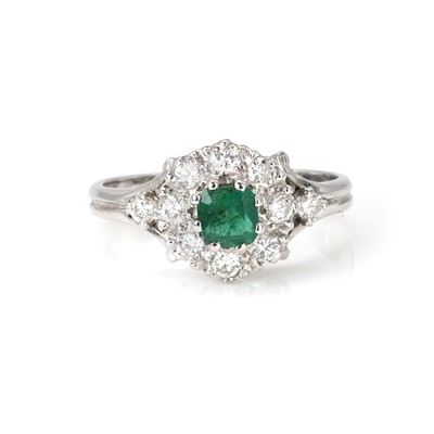 Lot 96 - An 18ct white gold emerald and diamond cluster ring