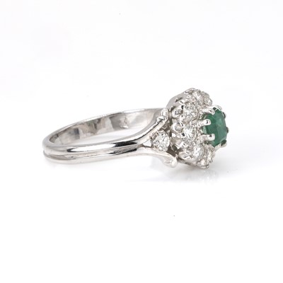 Lot 96 - An 18ct white gold emerald and diamond cluster ring