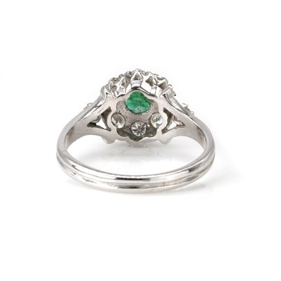 Lot 96 - An 18ct white gold emerald and diamond cluster ring
