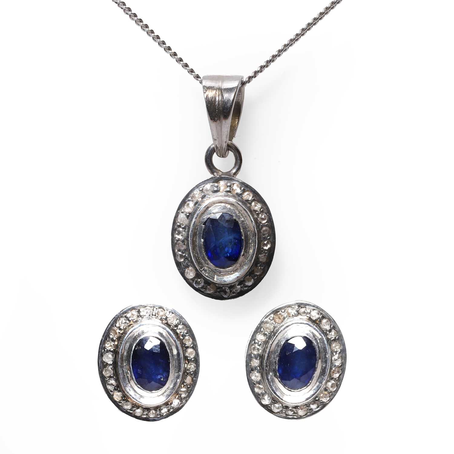 Lot 1224 - A pair of oval sapphire studs and a sapphire pendant