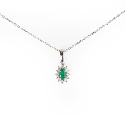 Lot 1081 - An 18ct white gold emerald and diamond cluster pendant