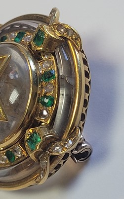 Lot 8 - A shield-form rock crystal, emerald and diamond brooch