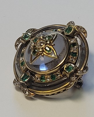 Lot 8 - A shield-form rock crystal, emerald and diamond brooch