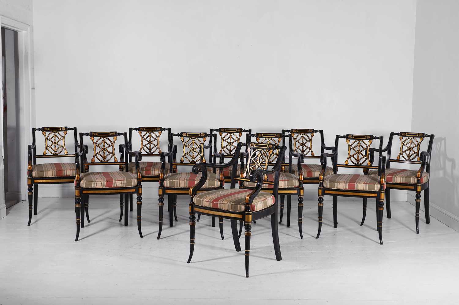 Lot 11 - A set of ten Regency-style black and gilt-painted wooden dining chairs