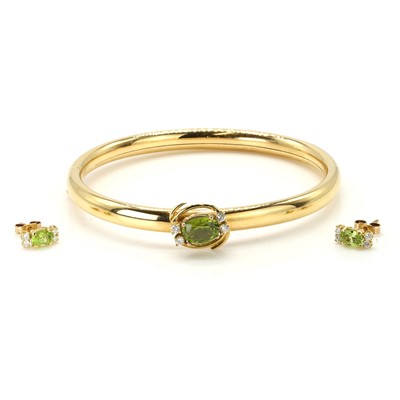 Lot 89 - A gold peridot and diamond bangle and earring set