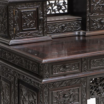 Lot 221 - A Chinese carved hardwood kneehole desk