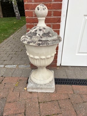 Lot 532 - A pair of reconstituted garden urns, with integral covers