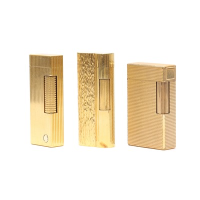 Lot 1329 - A group of three gilt metal lighters