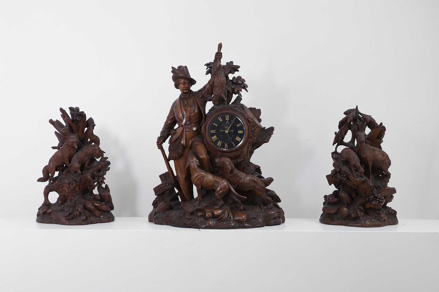 Lot 237 - A carved Black Forest clock garniture by Bergen & Co.
