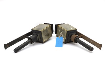 Lot 479 - A pair of patinated black coach lamps