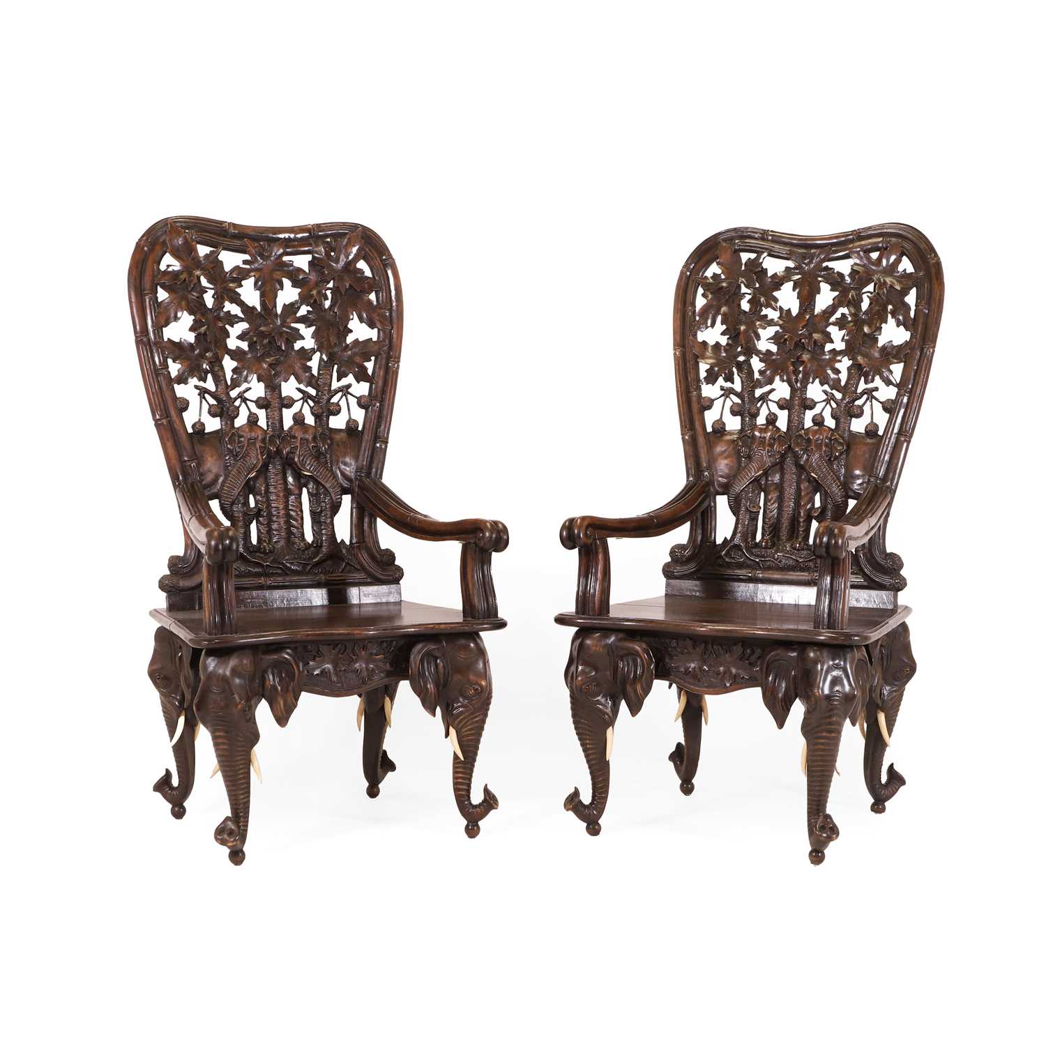 Lot 41 - A pair of carved linden wood Black Forest elbow chairs