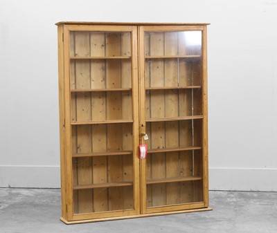 Lot 518 - A slender pine two door display cabinet