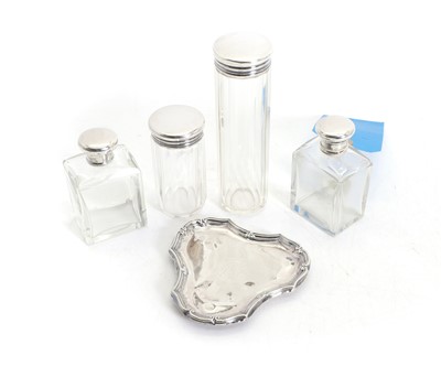Lot 2 - Four clear glass bottles with silver covers
