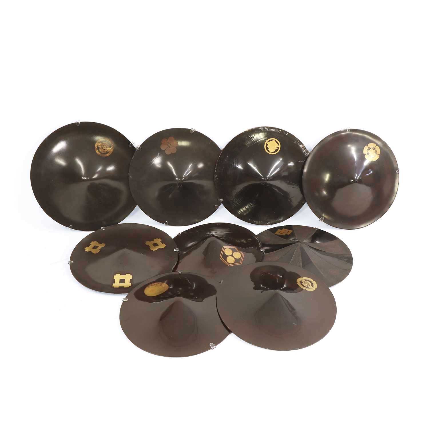 Lot 73 - A group of nine black-lacquered Samurai 'jingasa' hats