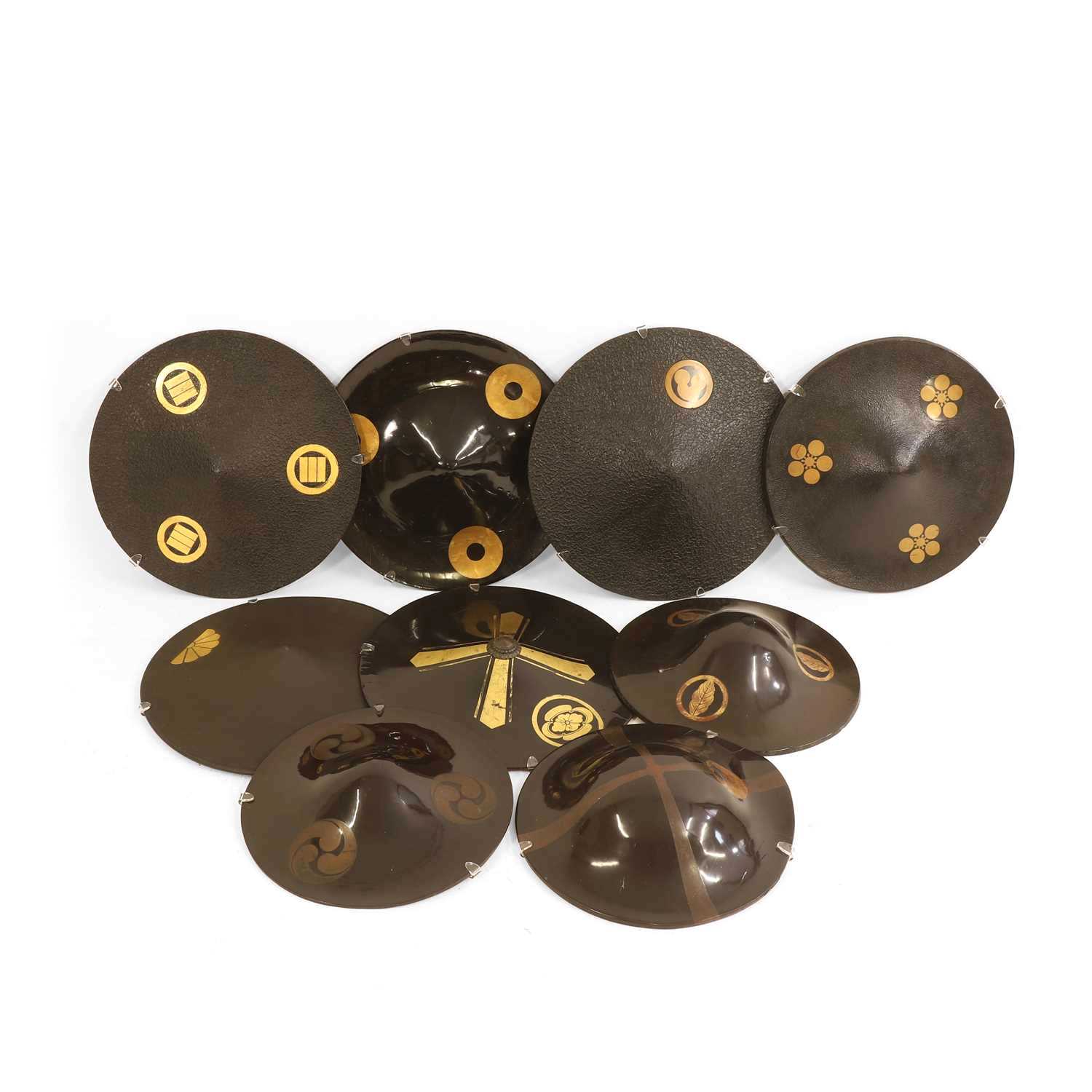 Lot 74 - A group of nine black-lacquered Samurai 'jingasa' hats